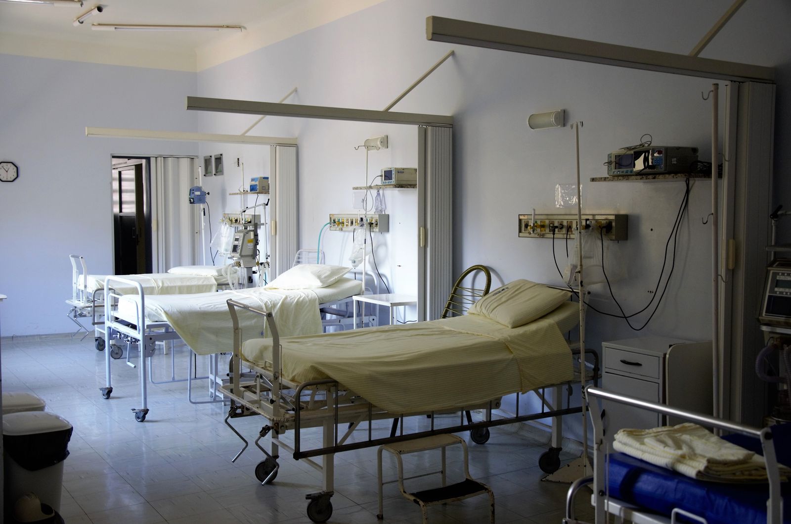 Quiet recovery room with made hospital beds and wall-mounted monitors