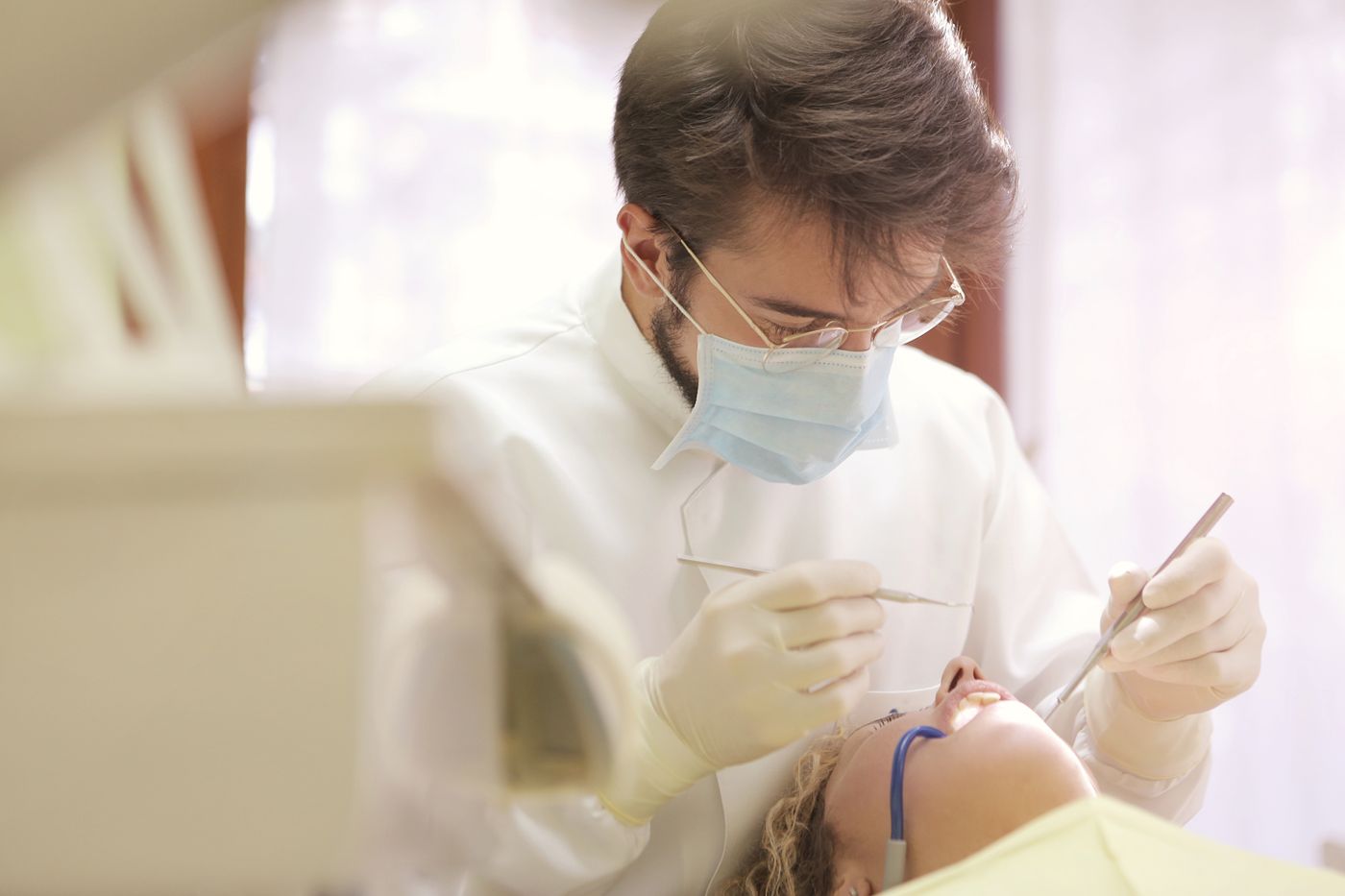 Oral and maxillofacial surgeon treating a patient in a clinical suite
